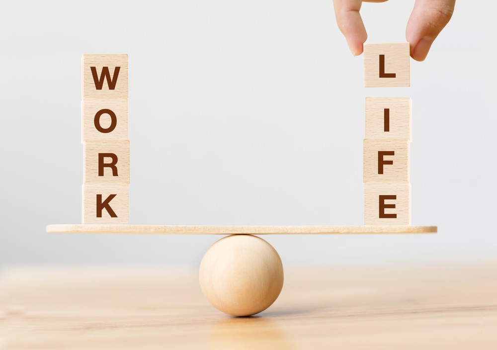Wooden cube block with word WORK and LIFE on seesaw