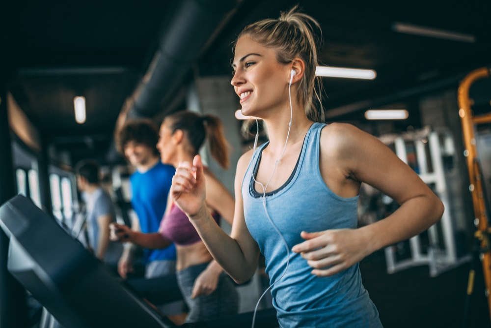 Young people running on a treadmill in health club